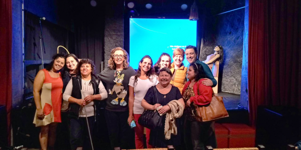 Grupo de atores com pessoas com deficiência e audiodescritores, logo após a peça.