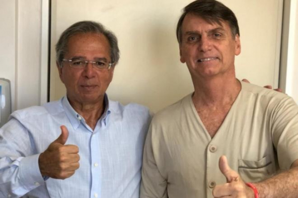 Guedes ao lado de Bolsonaro, em foto feita quando o presidente rec\u00e9m-eleito ainda se recuperava de uma facada sofrida durante ato de campanha em Juiz de Fora (MG)