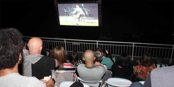 Alex (de cinza, ao centro) assiste ao documentário 'Alex Câmera 10' no Couto Pereira