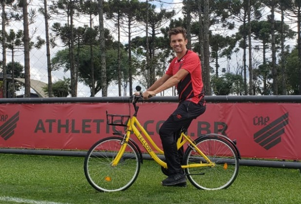 O zagueiro Paulo André, do Athletico, usa uma bicicleta da Yellow no CT do Caju