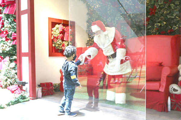 Papai Noel de shopping: em 2020, atrás de vidraça