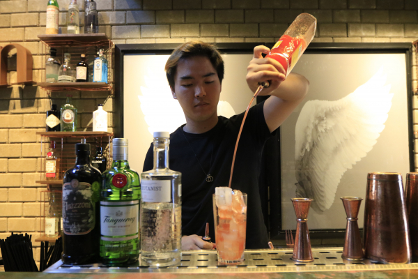 Bartender preparao um coquetel a base de gin: sofisticação